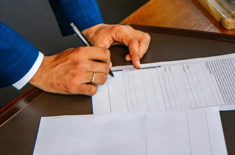 Profesional firmando documentos en un escritorio